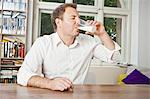 Man drinking glass of milk at table