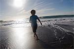 Boy playing in waves on beach