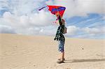 Boy flying kite on beach