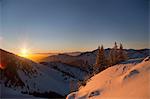 Sun setting over snowy landscape