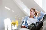 Smiling woman relaxing on sofa