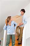 Couple carrying cardboard box