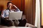 Businessman using laptop in hotel room
