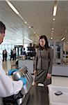 Security Guard Examining Woman's Suitcase at Baggage Check in Airport