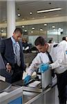 Security Guard Checking Businessman's Briefcase at Airport