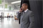 Homme d'affaires à l'aide de téléphone portable à l'aéroport