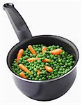 Saucepan of peas and young carrots