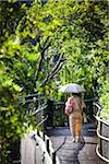 Frau zu Fuß mit Sonnenschirm auf Ryukyu Mura, Onna, Okinawa, Ryukyu-Inseln, Japan