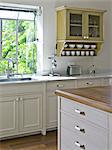 Wall mounted kitchen cabinet next to sink at window. Ramhash Munjak, Israel.