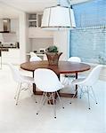 Wooden table below oversized pendant light, Addison Road, UK.