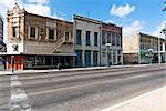 View of renovated buildings with man sat on bench outside, San Antonio city centre, Texas.