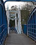 Ein Mann, mit dem Fahrrad über die Hängebrücke über den Fluss Themse in Teddington Lock.