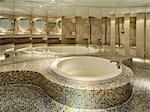 Penthouse suite in Pier One boutique hotel, Suzhou Creek, Shanghai, opened 2006. Converted from the former 1930s Union Brewery by Art Deco architect Ladislaus Hudec. Round bath with mosaic, and a curved mirror wall in sections.