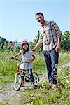 Father and daughter on bike outdoors