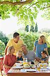 Multi-generation family having breakfast outdoors