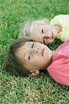 Boy and girl lying on grass, portrait