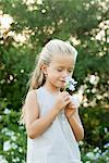 Girl smelling flowers, eyes closed