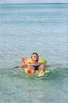 Young man relaxing on pool raft in sea