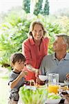 Boy und Großeltern mit Mahlzeit im freien
