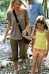 Mother and daughter walking hand in hand outdoors