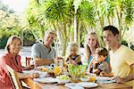 Famille multigénérationnelle au petit déjeuner de table en plein air, portrait