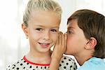 Boy whispering in girl's ear