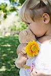 Kleines Mädchen hält, Teddybär, Blumen- und Schnuller