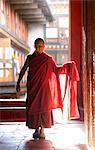 Moine bouddhiste de Young en rouge robes rétro-éclairé par le soleil de soirée à la Jakar Dzong, Jakar, Bumthang, Bhoutan, Asie