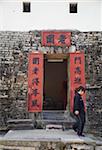 Femme sortant de la porte du village fortifié de Lo Wai, Fanling, New Territories, Hong Kong, Chine, Asie