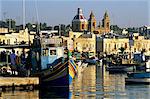View across harbour with traditional Luzzu fishing boats, Marsaxlokk, Malta, Mediterranean, Europe