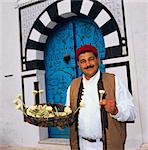 Jasmine seller in doorway, Sidi Bou Said, Tunisia, North Africa, Africa