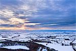 Untergang von Sonne und stürmischen Wolken über ein Schnee bedeckt Gormire See von Sutton Bank am Rande der North Yorkshire Moors, Yorkshire, England, Vereinigtes Königreich, Europa