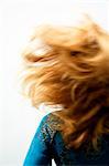 Jeune femme aux cheveux blonds, vue depuis l'arrière, mouvement flou, gros plan (studio)