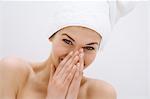 Portrait of a young woman looking at the camera, white hand towel on her head