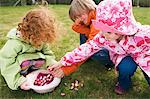 3 Kinder im Garten mit Ostereiern