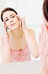 Young woman in front of bathroom mirror