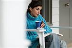 Young woman reading, sitting on a chair, outdoors