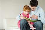 Homme et petite fille lisant le livre pour enfants