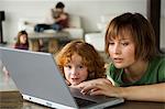 Woman and little girl using laptop computer