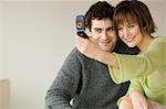 Smiling couple taking picture with camera phone