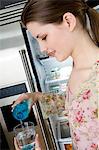 Young woman in profile pouring water into a glass