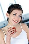 Portrait of a young smiling woman holding a glass of fruit juice