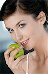 Portrait d'une jeune femme qui mange une pomme