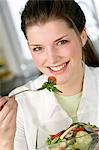 Porträt einer jungen lächelnde Frau Essen gemischter Salat