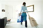 Woman carrying a bag and a shopping trolley in a living-room