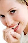 Portrait of a young woman smiling, lookig at the camera, indoors (studio)