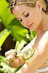 Portrait of a young woman brushing her arm, outdoors