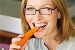 Portrait of a woman biting carrot