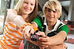 Teenage boy and girl using remote control