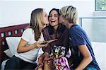 Teenage boy ang girl with gifts, kissing smiling woman